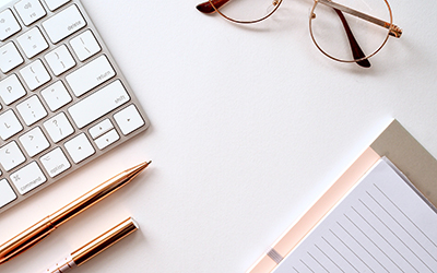 Keyboard, pair of glasses, pens and notepad