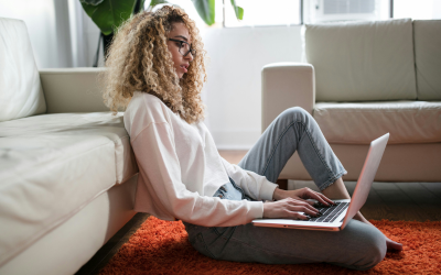 A woman sitting on the floor with her laptop