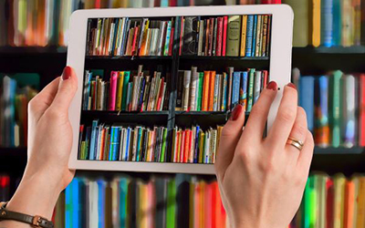 Person holding an iPad with images of books displayed on screen