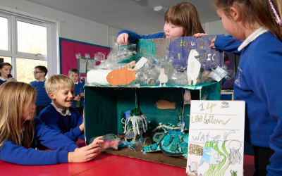 Primary school pupils working on an art project together