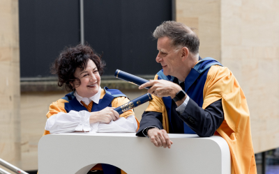Lorraine McIntosh and Ricky Ross holding graduation scrolls