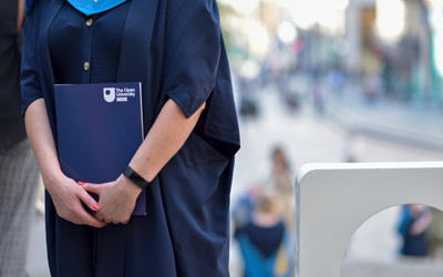 Graduate holding OU folder. Photo Credit: Julie Howden