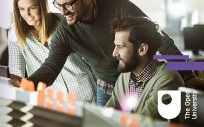 Three people looking at a computer together. 