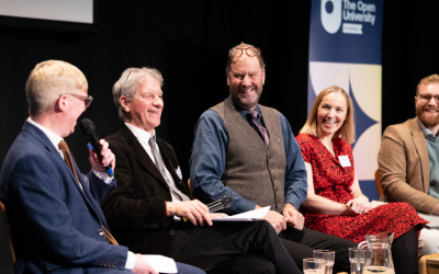 Five event speakers seated side-by-side on stage.