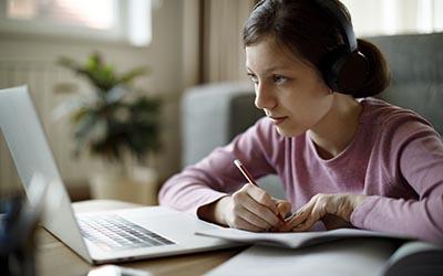 Teenage girl using laptop for studying at home