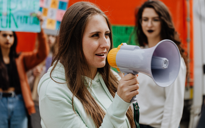 Photo of a woman with a megaphone, by Karolina Grabowska on Pexels. 