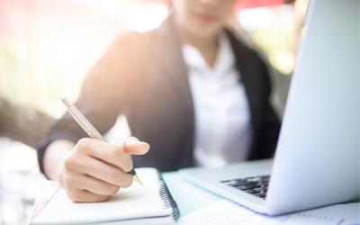 Woman with notepad and laptop