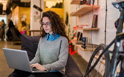 A woman seated, using a laptop