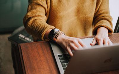 Hands typing on a laptop