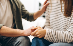 People holding hands, supporting through grief