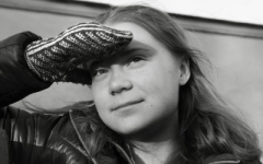 Black and white photo of Greta Thunberg looking into the distance with her hand shielding her eyes. Photo by Kim Jakobsen