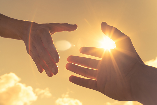 Giving a helping hand on sky background relief and support concept