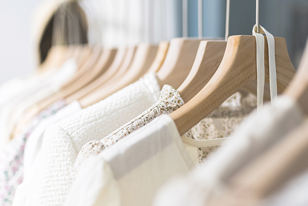 Row of different female clothes hanging on rack in hipster fashion show room in shopping mall trendy women wear