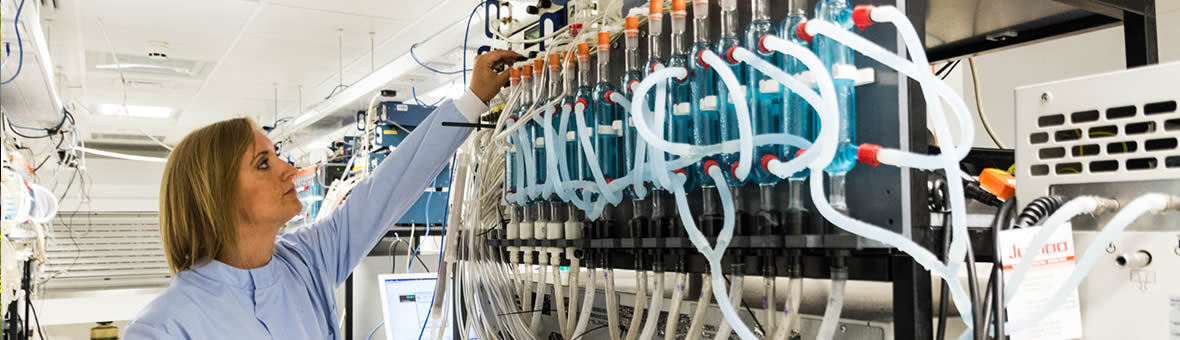Female scientist making an adjustment to a large complex experiment.