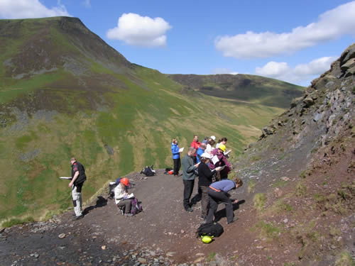 Students examining the bottom of a rockface