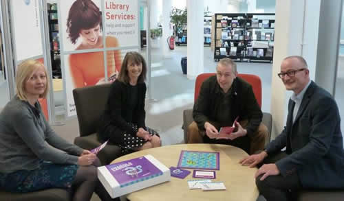 Four academics sitting around a table all looking at the camera