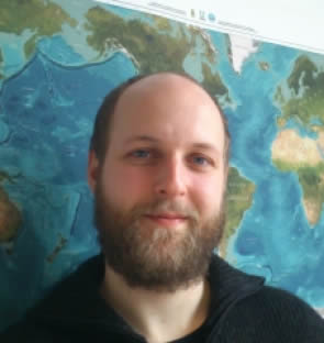 Andreas Wernecke - a man stands in front of a map of the world.