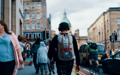 Person walking through city street wearing headphones