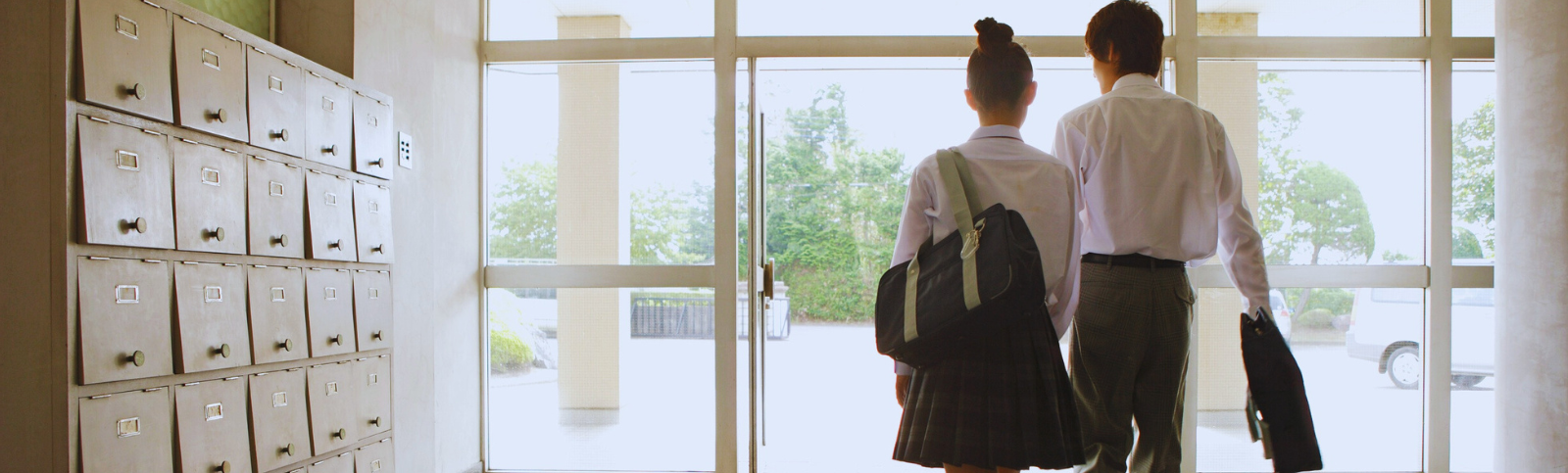 Two pupils in school uniform walking. Dwy disgybl mewn wisg ysgol yn cerdded.