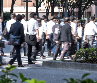 Teithwyr sy'n teithio i'r gwaith yn cerdded ar draws croesfan sebra