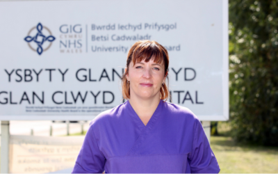 nurse in front of a hospital sign