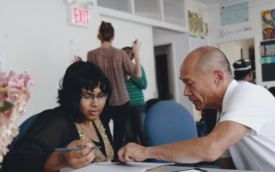 Volunteer helping someone with their writing