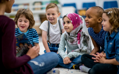 Children listening to a teacher read a story