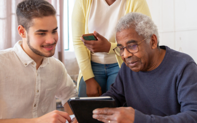 Man helping an elderly man with an iPad