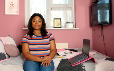student sat with laptop on bed