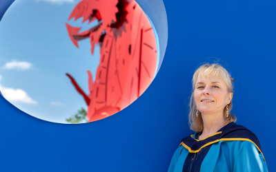 Beck at degree ceremony in front of OU shield