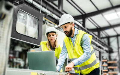 Workers at a computer in high vis vests