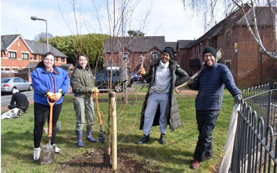 OU in Wales staff planting a tree