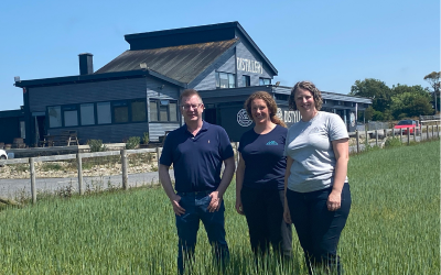 Dr Geraint Morgan a staff In The Welsh Wind o flaen y ddistyllfa