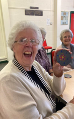 Woman holding up a small piece of art