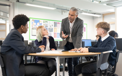 Teacher talking to a group of students at a table