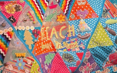 Embroidered patchwork quilt saying 'reach back in time'