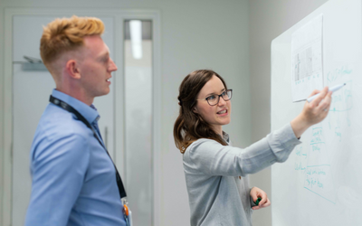 Students writing on a whiteboard 